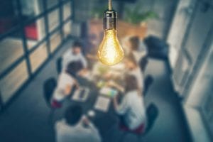 Light bulb shining above conference table