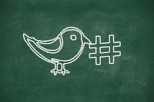 Twitter bird and a hashtag drawn on a chalkboard 