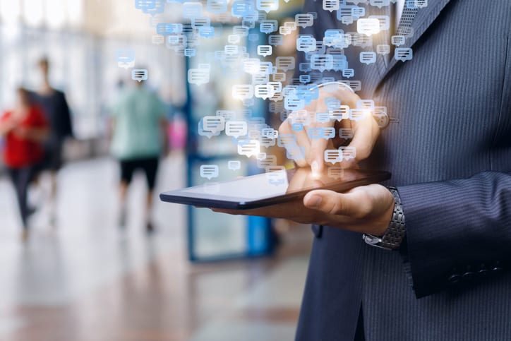 Businessman maintains correspondence on a tablet in a public place.