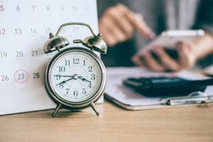 Alarm clock in front of a calendar