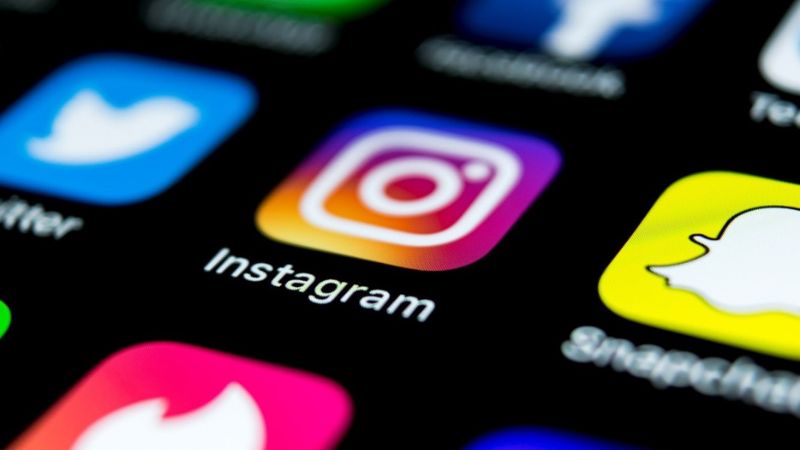 image of a cell phone face with apps blurred out except for the instagram app displayed int he middle of them
